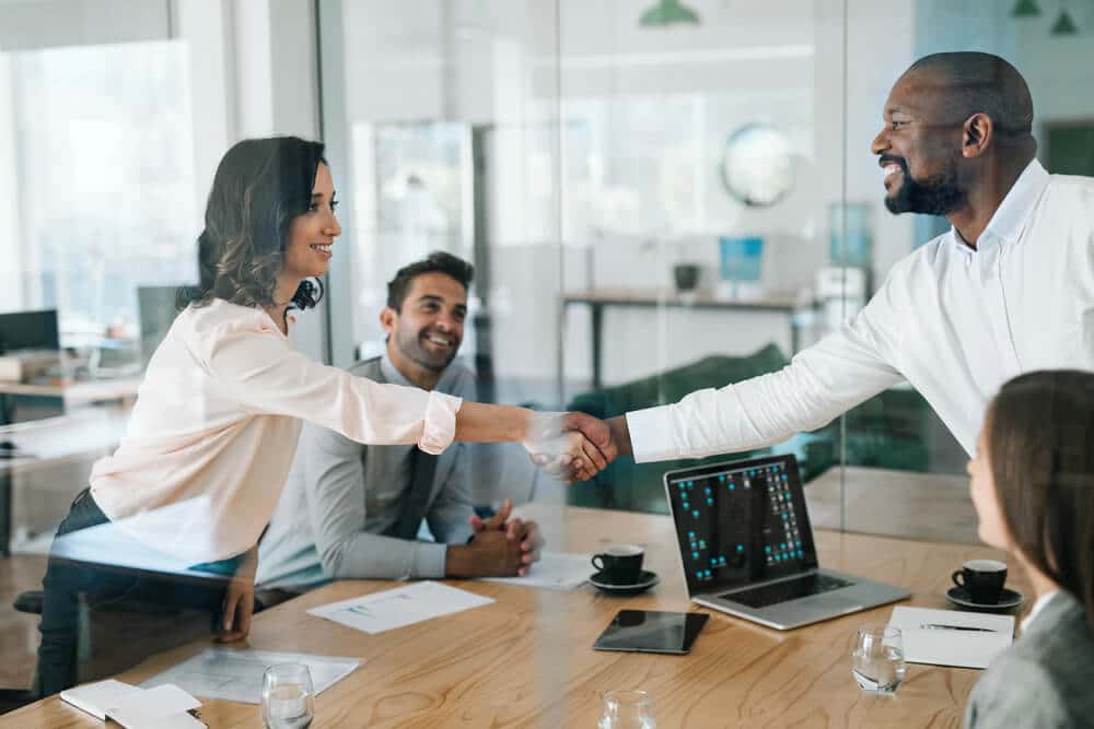 business people shaking hands across table