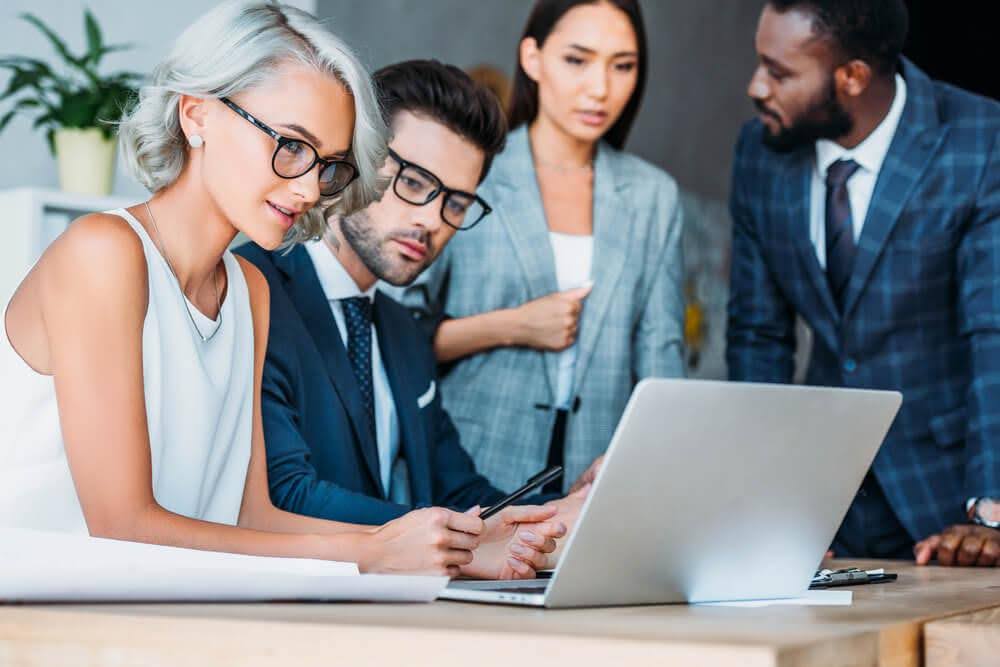 group of people working and looking at a computer